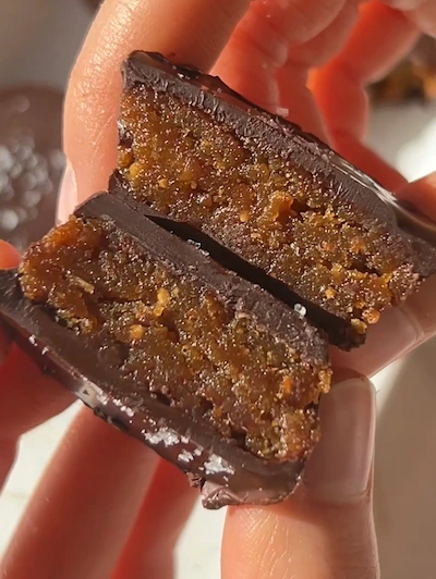 Healthy 3 ingredient dark chocolate peanut butter cups topped with flaky sea salt on a white marble surface