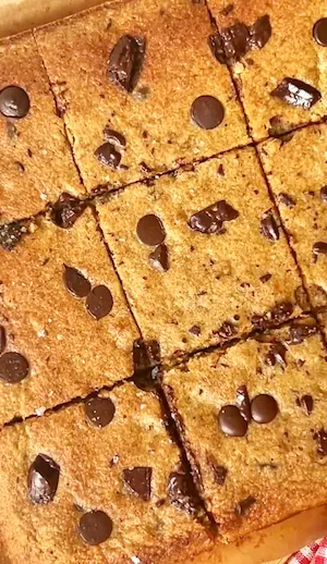 Chocolate chip banana bread bars cut into squares seen from above showing the golden baked texture with chocolate chips scattered throughout