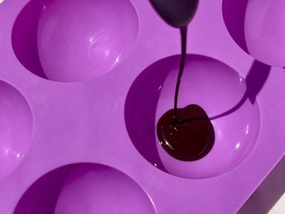 Step 1: Silicone molds lined with melted dark chocolate, showing the chocolate shell base ready for freezing