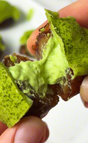 Cross section of a medjool date stuffed with creamy matcha cheesecake filling