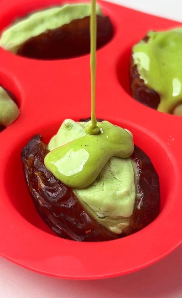 Step 3: Medjool dates stuffed with creamy matcha yogurt filling on a lined tray ready for the freezer